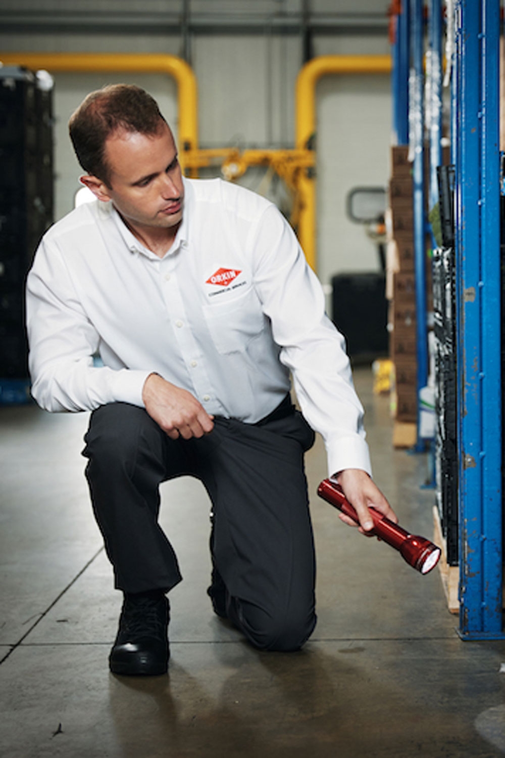 An Orkin Pro inspecting cases of food in a warehouse