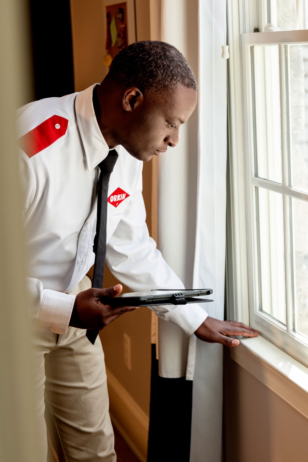 An Orkin Pro inspecting the windows in a customer's home