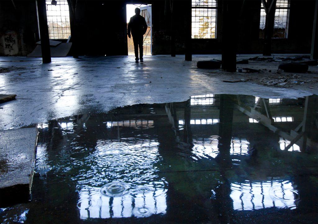 Man Standing in Storm-Damaged Building