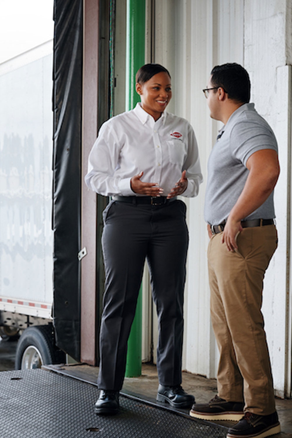 Two Orkin Pros standing in a warehouse